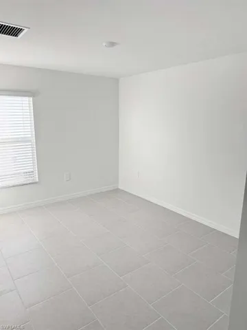 Spare room featuring light tile patterned flooring and baseboards