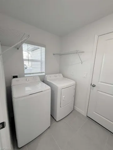 Laundry area featuring separate washer and dryer and light tile patterned floors