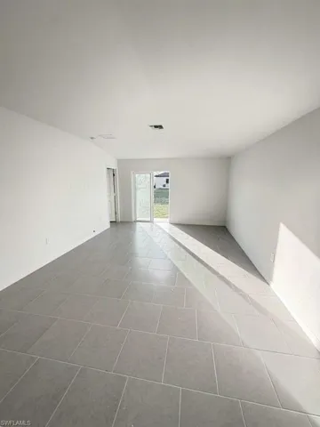 Unfurnished room featuring light tile patterned flooring and baseboards