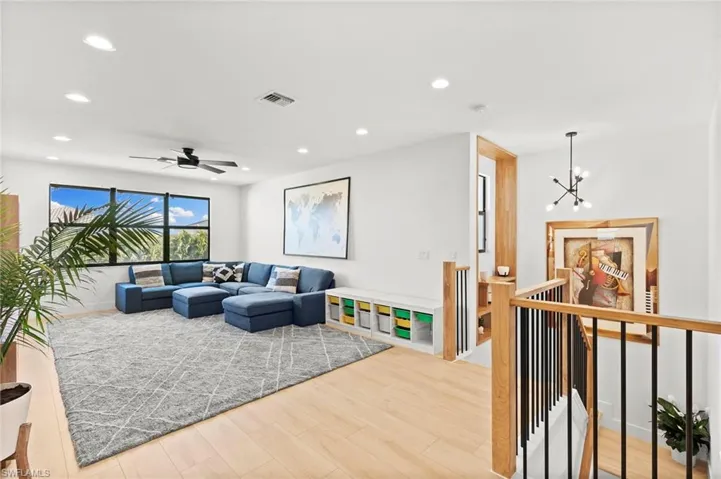Living room featuring wood finished floors, visible vents, and recessed lighting
