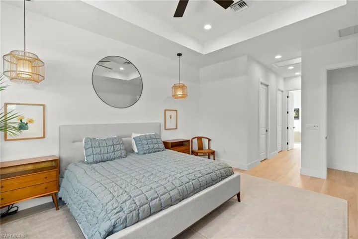 Bedroom with wood finished floors, baseboards, visible vents, and recessed lighting