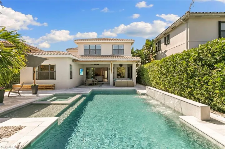 Rear view of house featuring stucco siding, an outdoor hangout area, ceiling fan, a pool with connected hot tub, and a tiled roof