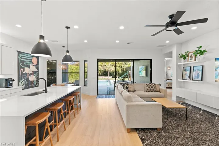 Living area with baseboards, recessed lighting, light wood-style floors, and a ceiling fan