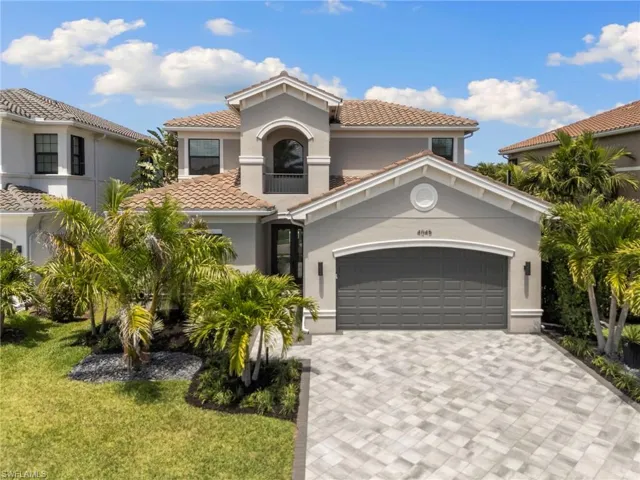 Mediterranean / spanish-style house featuring a tiled roof, stucco siding, a front lawn, and decorative driveway