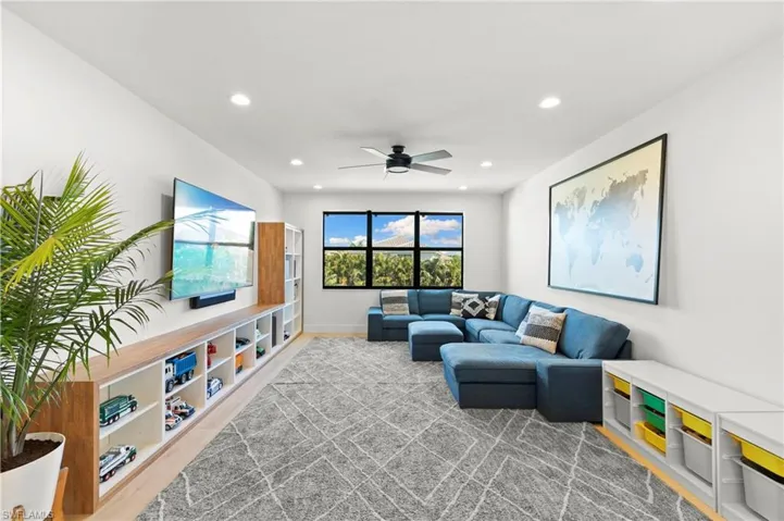 Living room with wood finished floors, baseboards, a ceiling fan, and recessed lighting