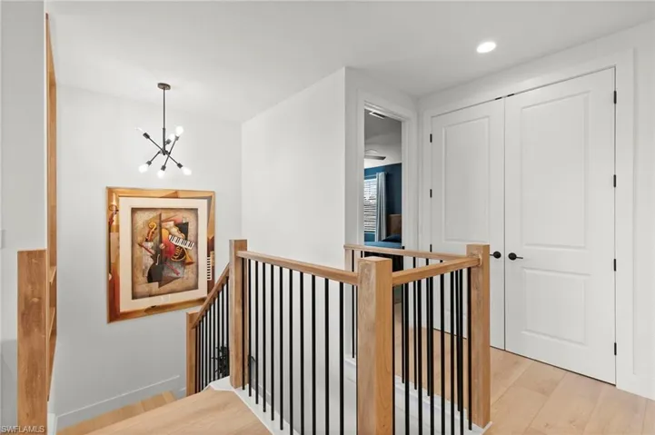 Hall featuring baseboards, an upstairs landing, a chandelier, recessed lighting, and light wood-style flooring