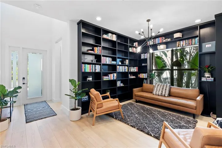 Living area with wood finished floors, an inviting chandelier, and recessed lighting