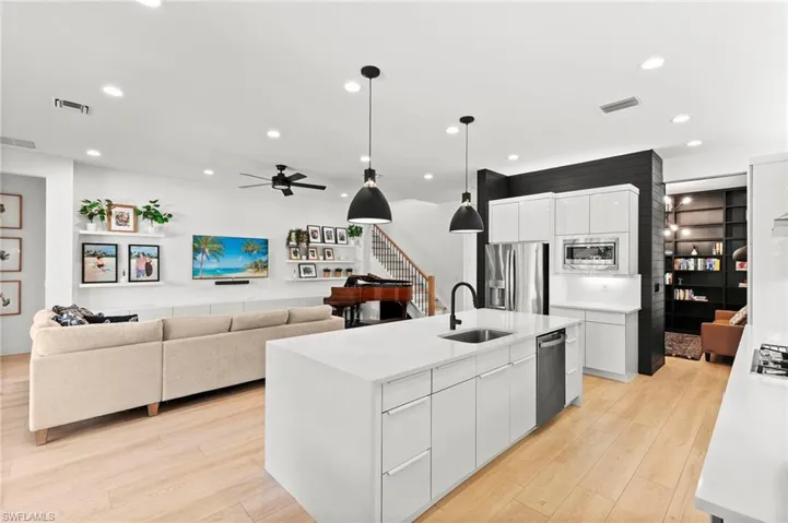 Kitchen featuring a sink, visible vents, appliances with stainless steel finishes, and light wood-style floors