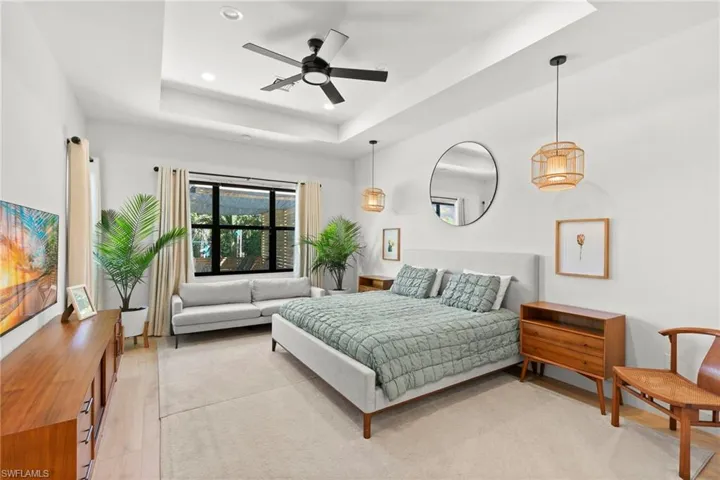 Bedroom featuring a tray ceiling, light wood finished floors, and recessed lighting