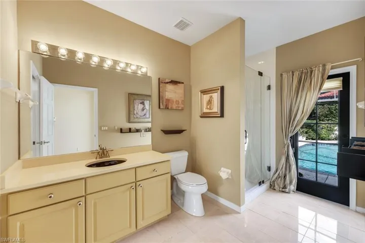 Guest bathroom feature a walk-in shower and pool access.