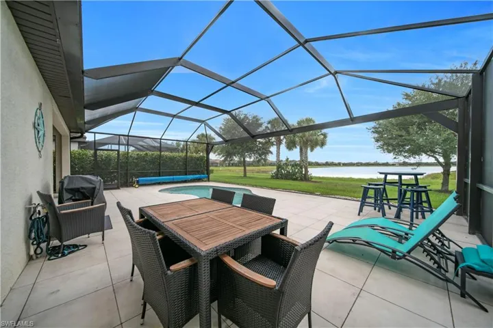 Screened lanai with a built-in swimming pool, a paver patio, and direct waterfront access