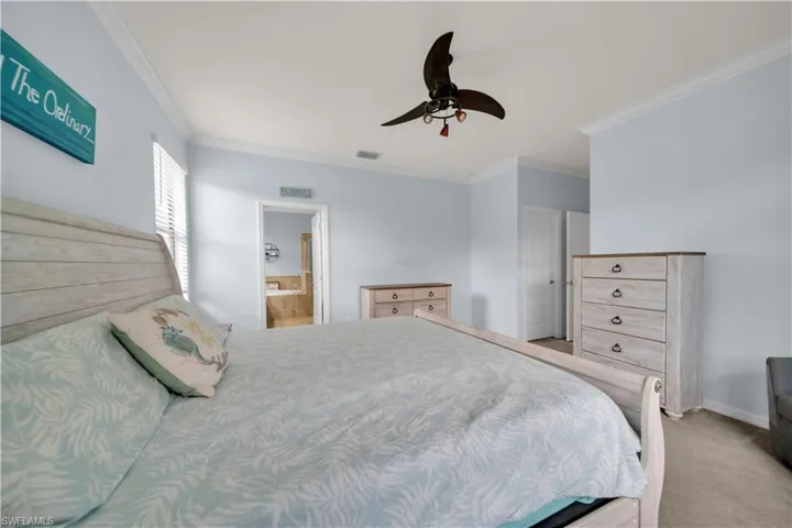 Vaulted ceiling with crown molding, ceiling fan, carpeted flooring, and a window with blinds