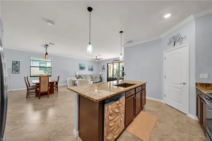 Kitchen island featuring a single basin sink and pendant lighting