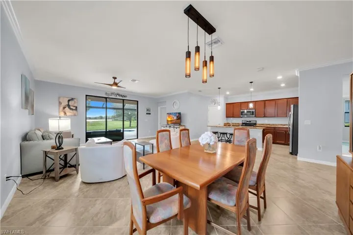 Open-concept living space featuring wood-finish flooring and a contemporary linear chandelier