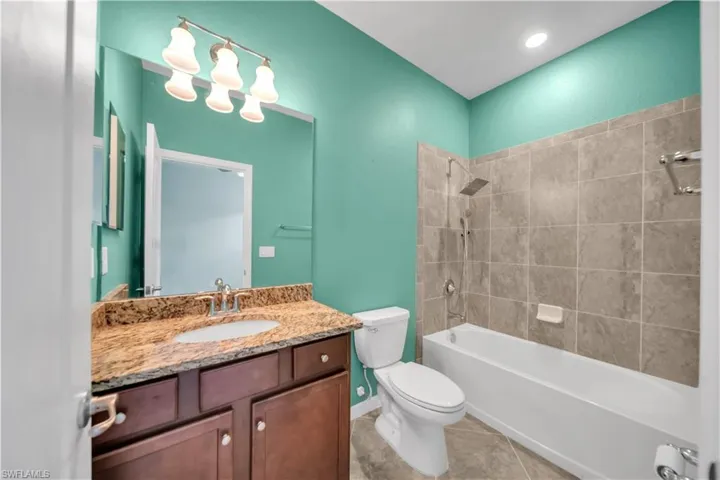 Brown wood vanity with a granite countertop and undermount sink