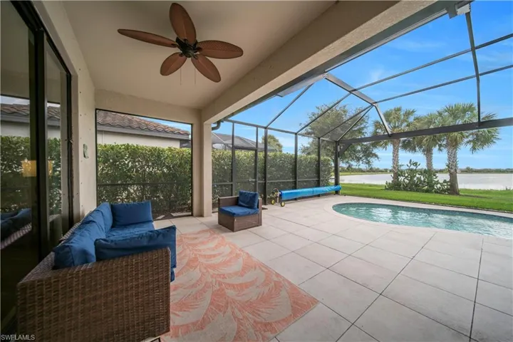 Screened lanai featuring a ceiling fan, outdoor pool, and water frontage