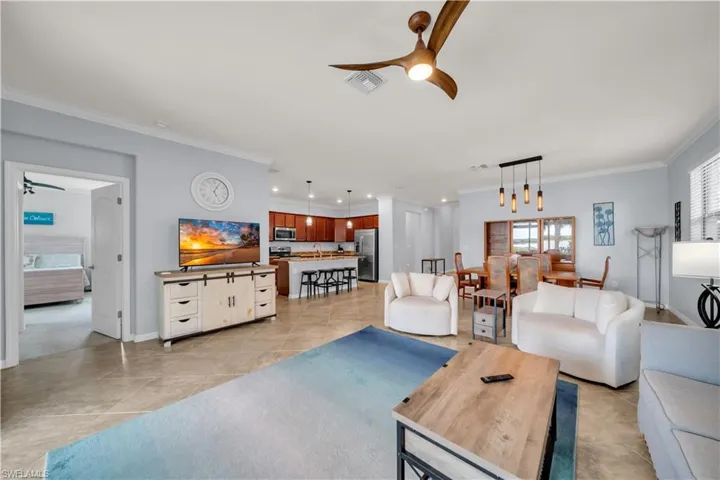 Open-concept living area with tile flooring and crown molding