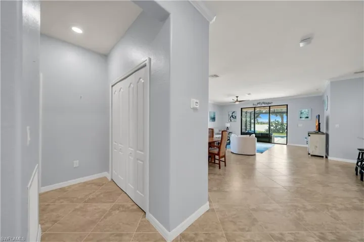 Tile flooring, recessed lighting, white crown molding, white baseboards, and sliding glass doors