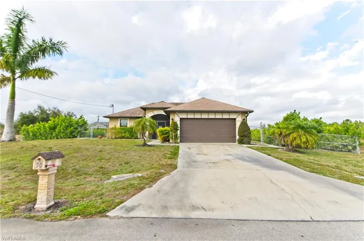 View of front of property featuring stucco siding, driveway, and a garage