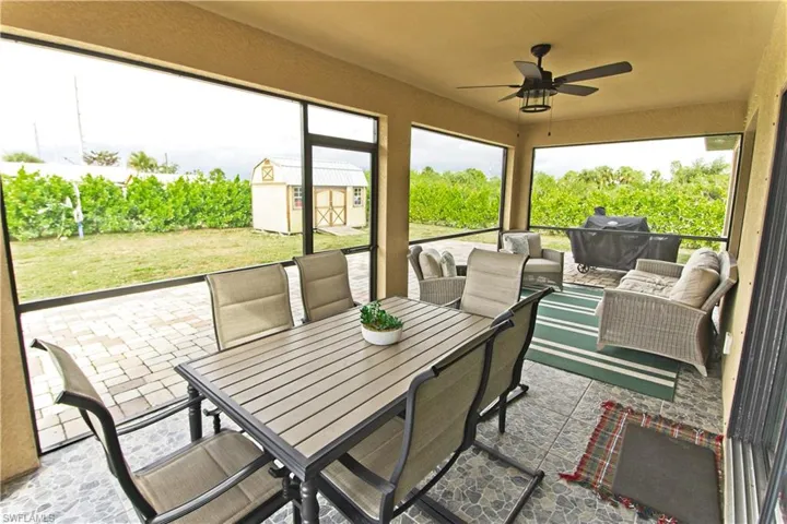 Sunroom / solarium with outdoor dining space, ceiling fan, and an outdoor living space