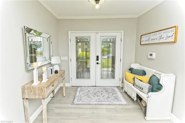 Doorway to outside with french doors, wood finished floors, and crown molding