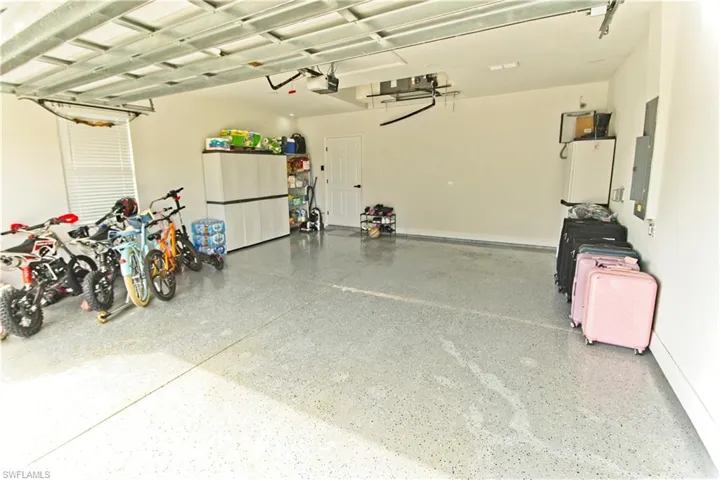 Garage featuring electric panel and a garage door opener