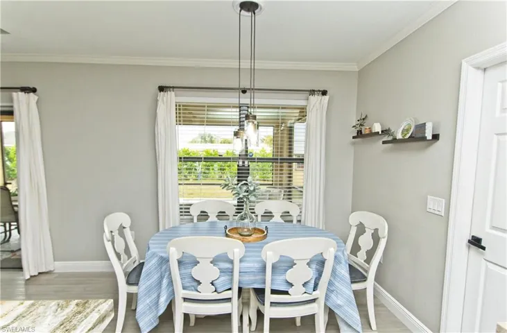 Dining space featuring wood finished floors and ornamental molding