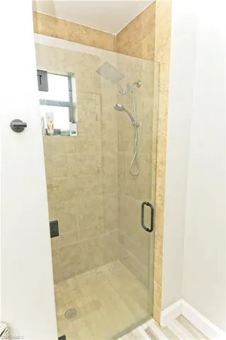 Bathroom featuring a stall shower and baseboards