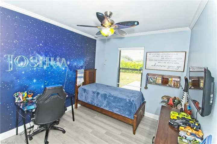 Bedroom featuring crown molding, wood finished floors, ceiling fan, and an office area