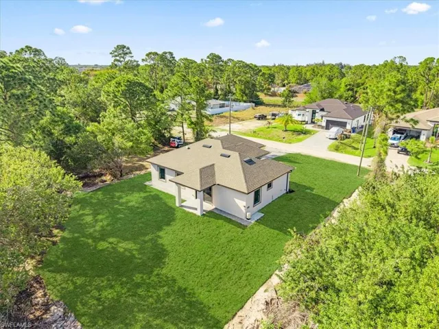Aerial view of property and surrounding area with a tree filled landscape