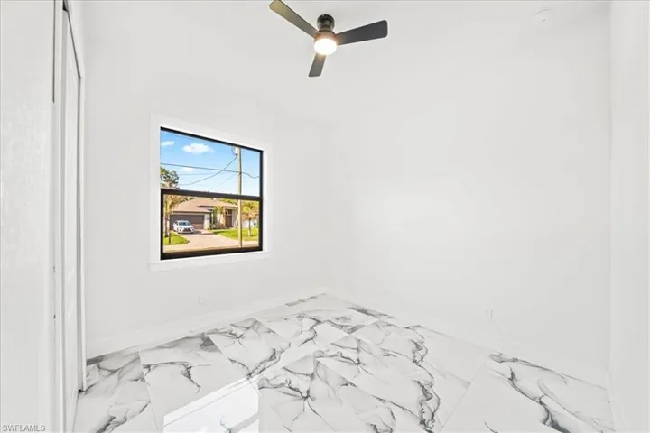 Spare room featuring ceiling fan and light marble finish floors