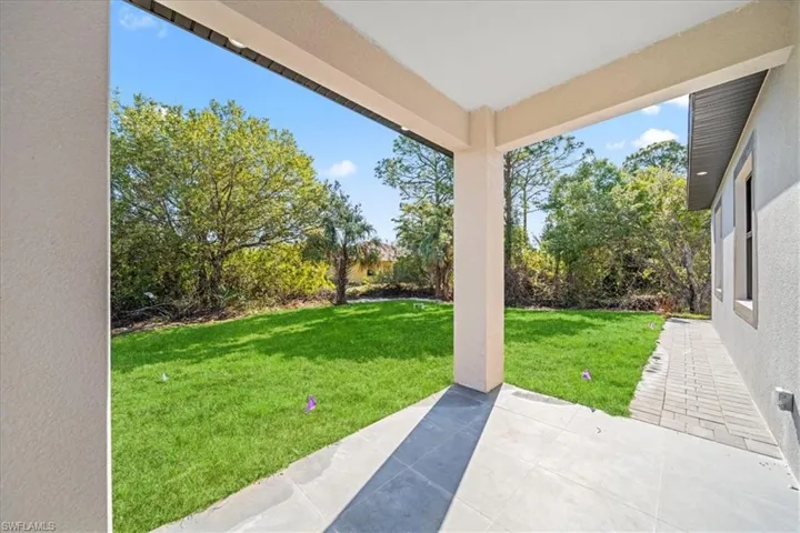 View of grassy yard with a patio