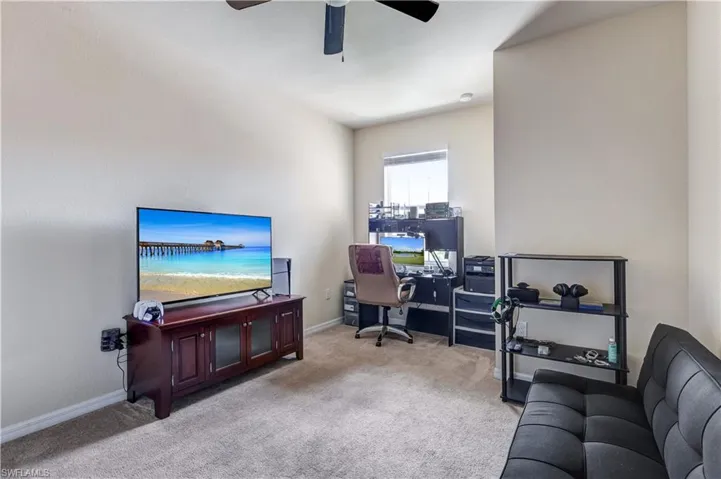 Office area with light colored carpet and ceiling fan