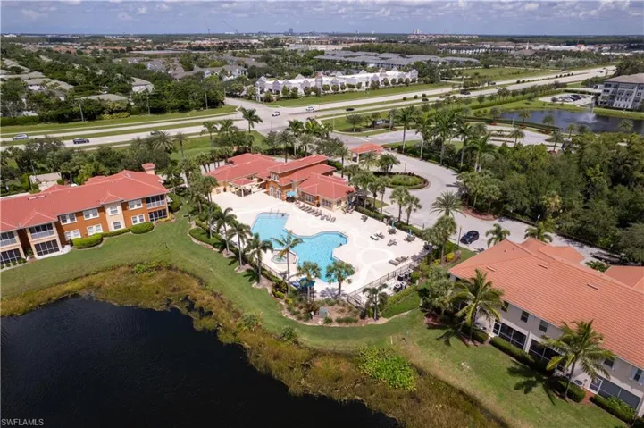 Aerial perspective of suburban area with a large body of water and a pool area