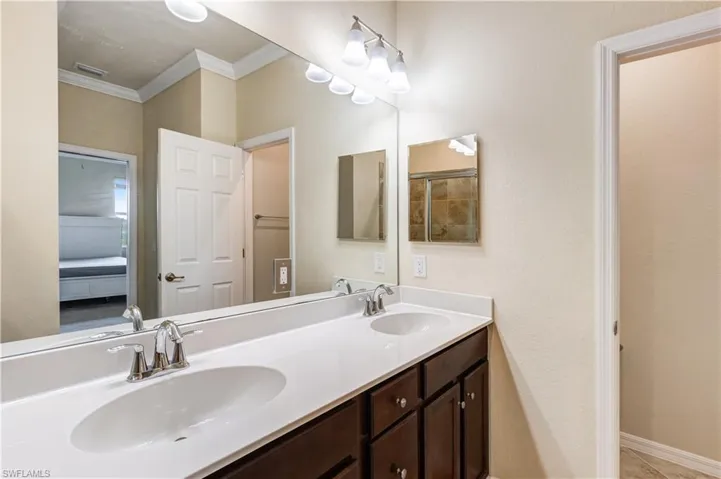 Bathroom featuring double vanity and ornamental molding