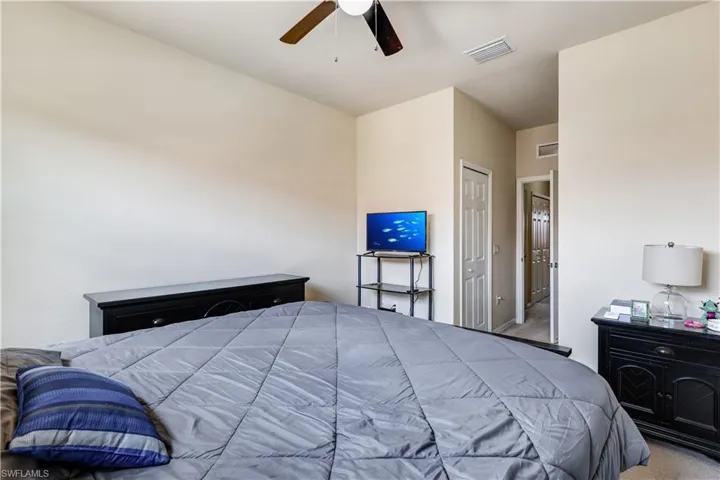 Bedroom with carpet, a closet, and a ceiling fan