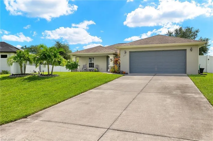 Single story home featuring a garage and a front yard