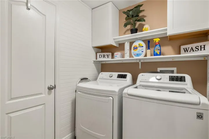 Washroom with washer and dryer and cabinets