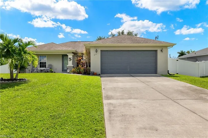 Ranch-style house featuring a garage and a front lawn