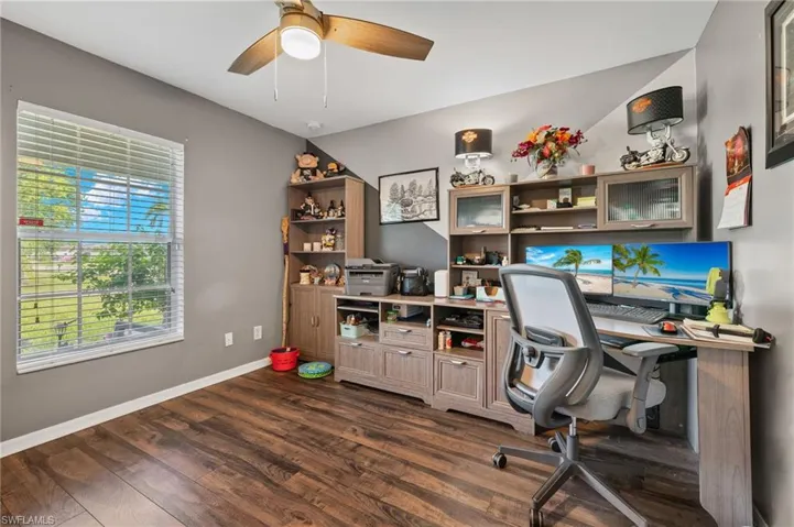 Office space with hardwood / wood-style flooring and ceiling fan