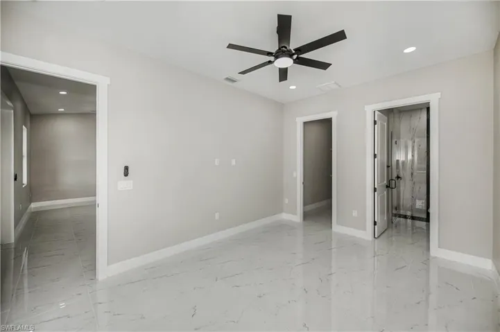 Unfurnished bedroom with recessed lighting, light marble finish flooring, ceiling fan, and connected bathroom