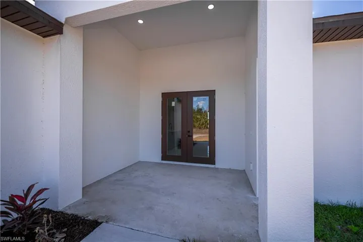 Property entrance with french doors, a patio, and stucco siding