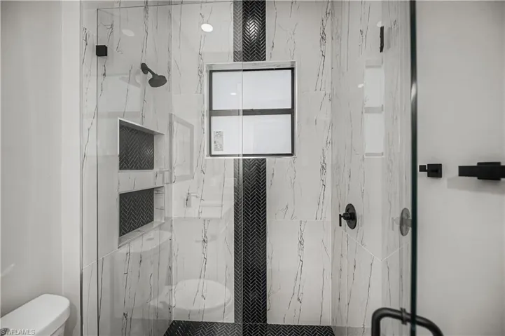 Full bathroom with a marble finish shower