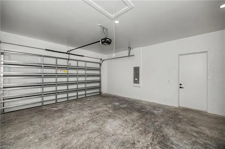 Garage featuring electric panel and a garage door opener