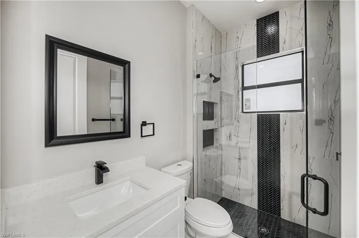 Bathroom with a marble finish shower and vanity