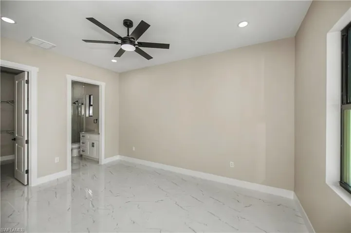 Unfurnished bedroom featuring a spacious closet, recessed lighting, ceiling fan, and light marble finish floors
