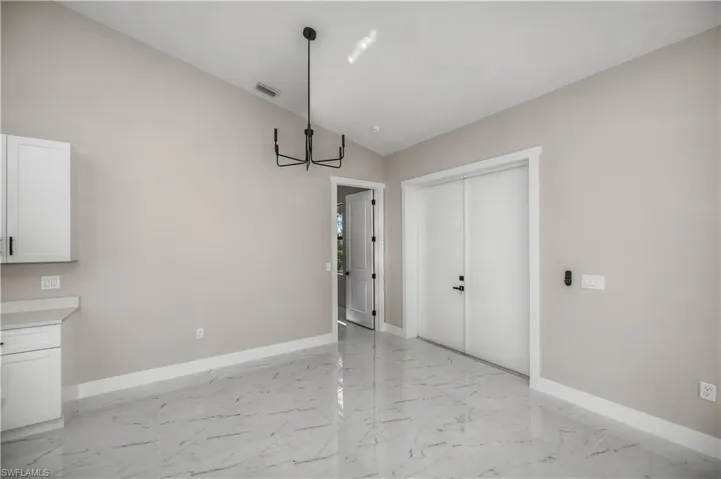 Unfurnished dining area featuring baseboards and suspended lighting
