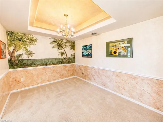 Formal dining area featuring tray ceiling and elegant lighting fixture.