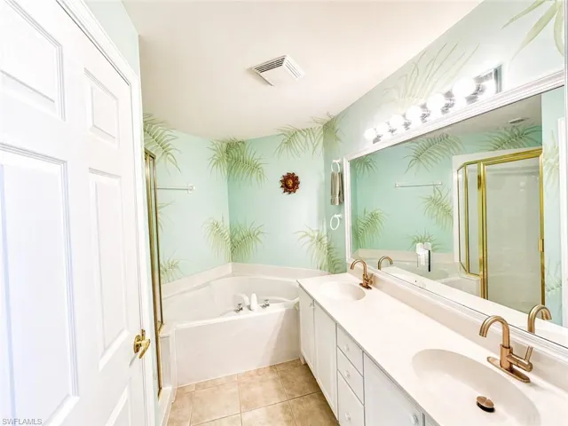 Primary bath with dual vanities, soaking tub, and separate walk-in shower.