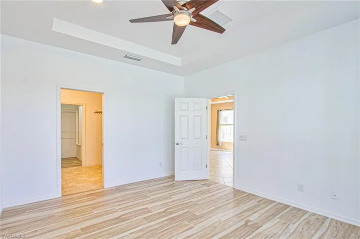 Primary bedroom w/tile flooring w/tray ceiling